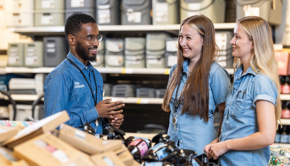 Tre Clas Ohlson medarbeidere som snakker med hverandre