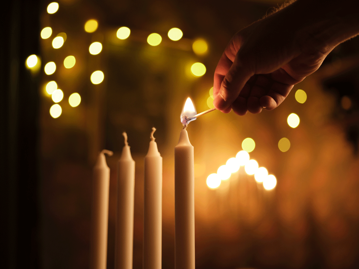 Kynttilöitä sytytetään adventtikynttelikössä