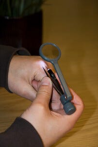 Förstoringsglas med pincett och belysning